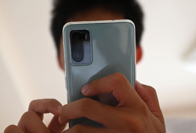 スマホを覗く男性の姿。