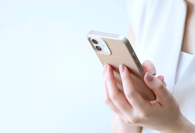 スマホを操作する女性の手元。