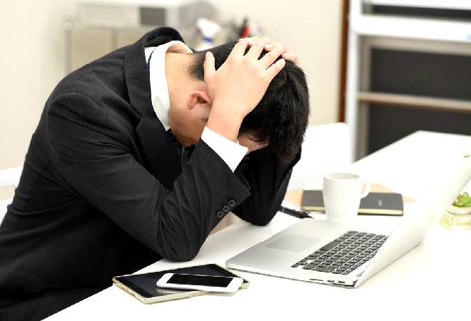 頭を抱える男性。