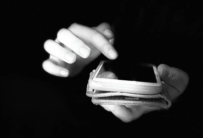 スマホを操作するモノクロ画像。